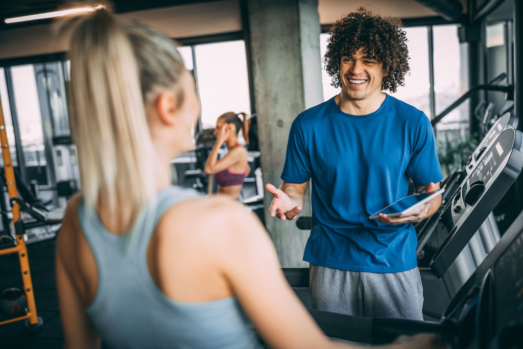 Young man talking to young woman at gym